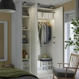 Open wardrobe display with clothing, storage solutions, and integrated lighting inside.