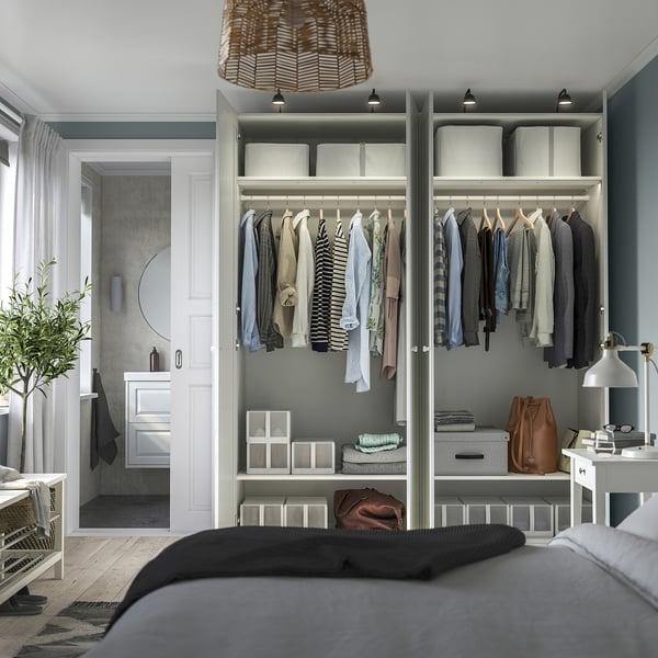 Modern bedroom with open wardrobe displaying neatly organized clothes, featuring adjustable shelves and integrated lighting.