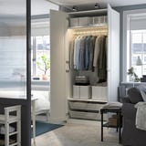 Open wardrobe with clothes, organized shelves, and storage boxes. Integrated lighting illuminates the closet space.