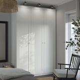 Bedroom with large white PAX wardrobe, black chair, and window.