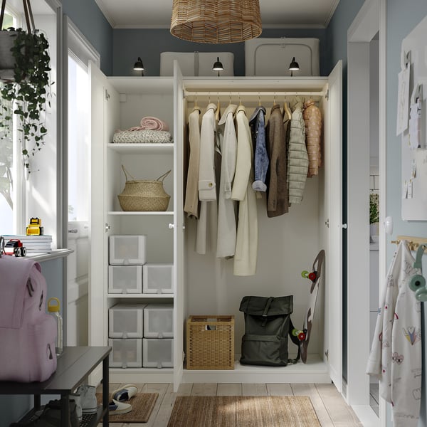 White PAX wardrobe with hanging, shelved, and lit storage spaces.