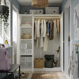 White PAX wardrobe with hanging, shelved, and lit storage spaces.