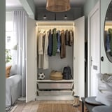 Organized closet with hangers, baskets, and shelves, showcasing wardrobe and accessories storage.