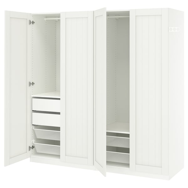 A white ikea PAX wardrobe with open doors revealing shelves and mesh drawers.