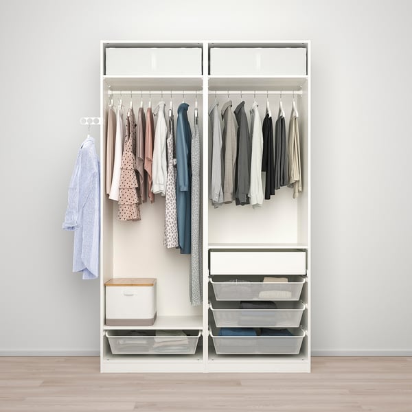 A white PAX wardrobe with sliding doors, hangers, baskets, and bins stores clothes and accessories, saving space.