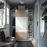 Modern closet with sliding doors and organized shelves. Grey and wooden tones. Space-saving design with integrated storage solutions.