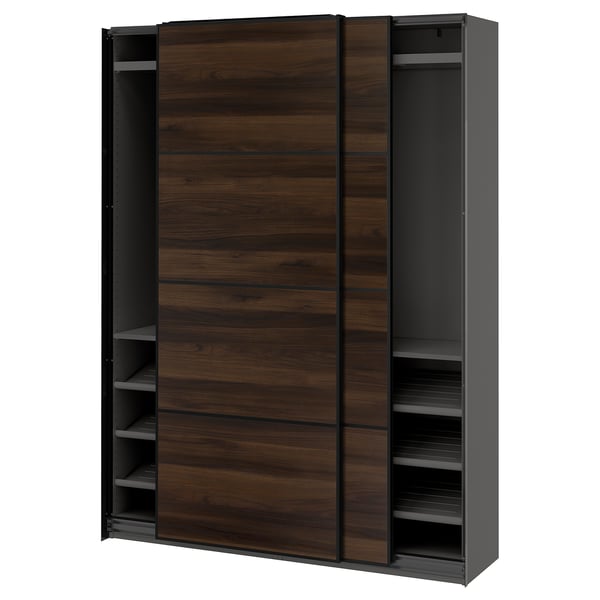 An IKEA PAX wardrobe with sliding dark wooden doors and black sides. It shelves and rails for storage.