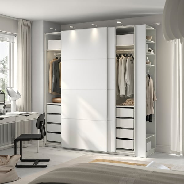 Modern bedroom with white PAX wardrobe, mirrored, lit, office desk, chair, lamp.