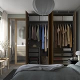 Modern bedroom with open wardrobe, stylish light fixture, and large window.