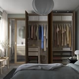 Modern bedroom with PAX wardrobe showing organized clothes, adjustable shelves, and soft-closing hinges.