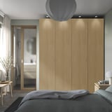 Modern bedroom with tall, lit PAX wardrobe & en-suite.