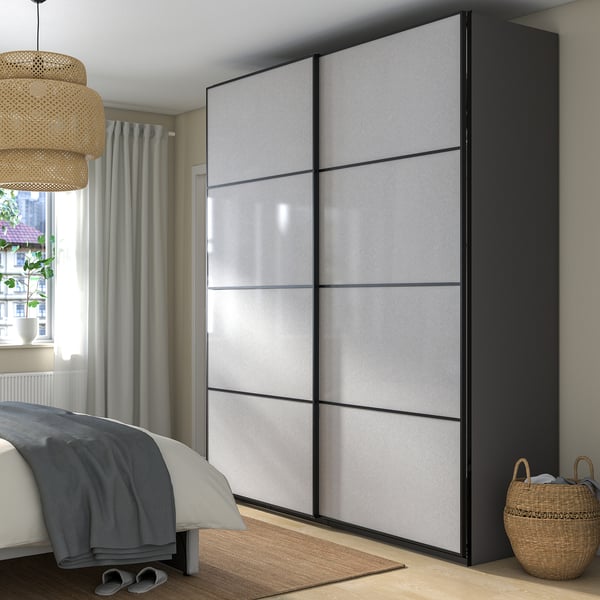 Large modern bedroom with gray PAX wardrobe, sliding doors, next to bed and window.