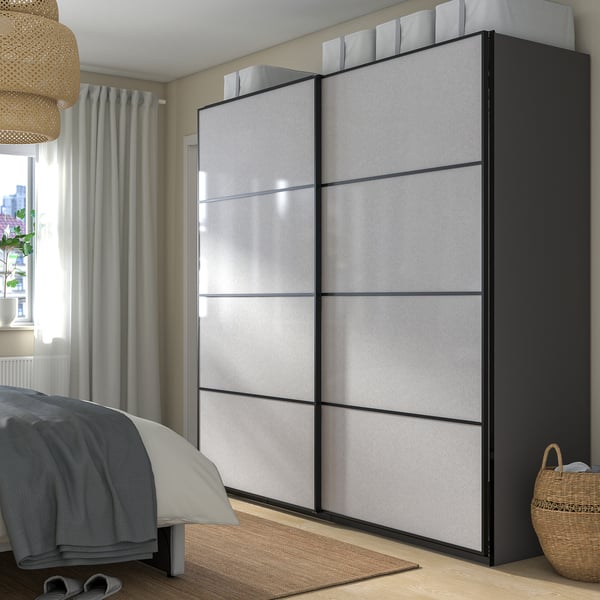 Modern bedroom with PAX wardrobe, blue bedding, lamp, and basket.