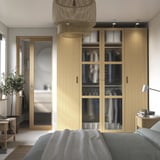 Modern bedroom with PAX wardrobe, glass doors, blue bed, pendant light.