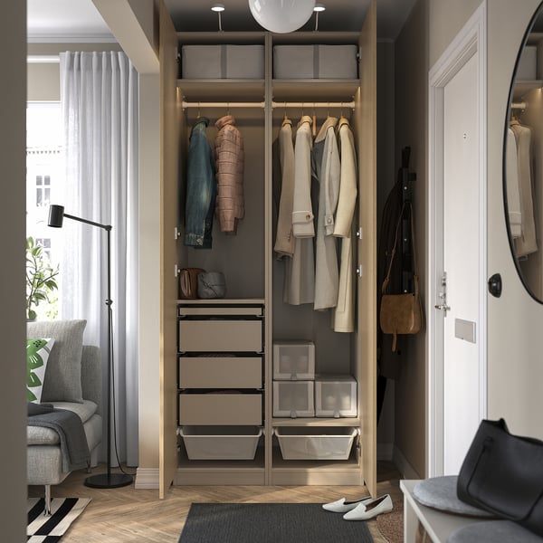 Open wooden wardrobe with clothes hangers, drawers, and boxes, showing storage and organization inside a cozy room.