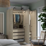 Bedroom with beige PAX wardrobe, clothes hangers visible, drawers with organizer mesh, soft-closing hinges, and built-in lights.