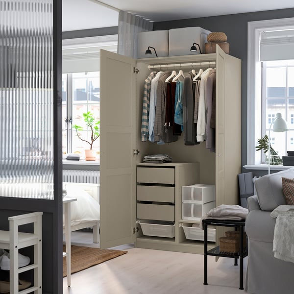 Open wardrobe displaying shirts, featuring hangers, drawers, and baskets for organized storage.