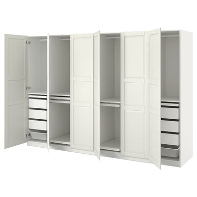 A white IKEA PAX wardrobe with open doors, showcasing adjustable shelves and drawers.