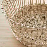 Handwoven natural sedge basket with intricate detail, perfect for dining table decor.