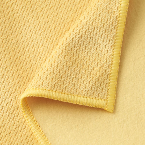 Close-up of a soft, yellow microfiber cloth highlighting its textured surface and neat, yellow hem stitching, showcasing its quality.