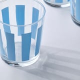 Clear glass cup with blue stripes, simple and stylish, perfect for beverages.