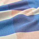 A colorful woven placemat with blue, orange, and white stripes.