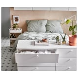 Modern bedroom with white PLATSA bed, gray linens, and storage drawers.
