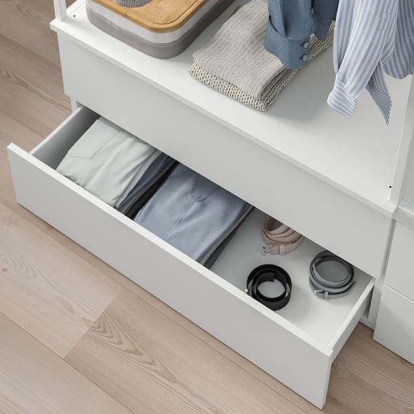White PLATSA drawer unit with open drawer showing folded clothes and belts, ideal for compact storage.