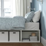 Bed with storage: PLATSA bed saves space, combining sleep & storage. Shelves hold boxes & books, ideal for small rooms.