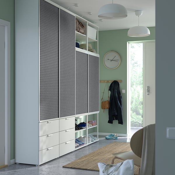 Modern entryway with tall grey PLATSA wardrobe, shelves, and hanging items. Sliding doors and a clothes rail.