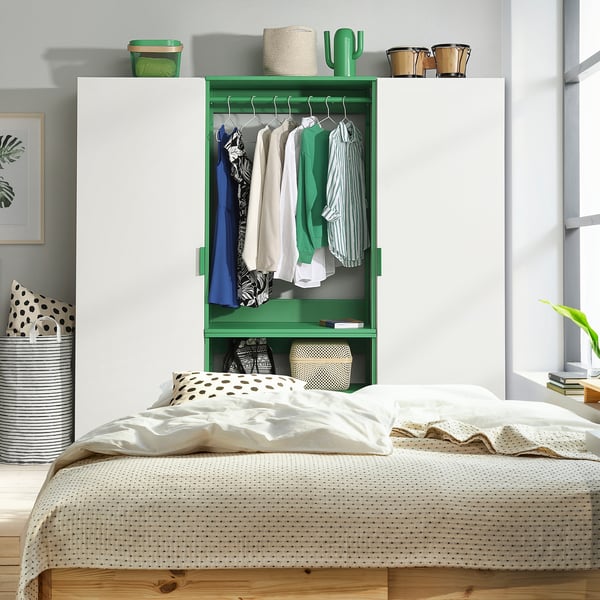 Modern bedroom with green PLATSA closet, wooden bed, and white bedding.
