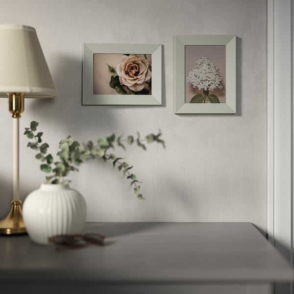 A modern room with flower photos and a lamp.