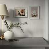A modern room with flower photos and a lamp.