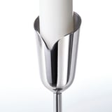 Elegant stainless steel candle holder with sleek, petal-like design. Holds white candle securely, reflecting light gracefully.