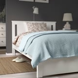 Blue PRAKTVIAL bedspread made from recycled polyester and cotton, neatly draped on bed.