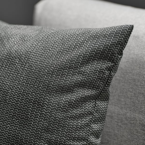 Close-up of soft, textured fabric pillow on a gray cushion, showcasing intricate weave and subtle shine.