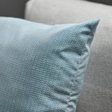 Cushion with subtle pattern resting on couch, showcasing quality fabric and design.