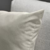Close-up of a cozy, light beige cushion with subtle pattern and soft sheen, designed for comfort and style.