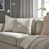 Modern living room with beige PROFETBLOMMA cushions on sofa, neutral tones, subtle texture, and shine.