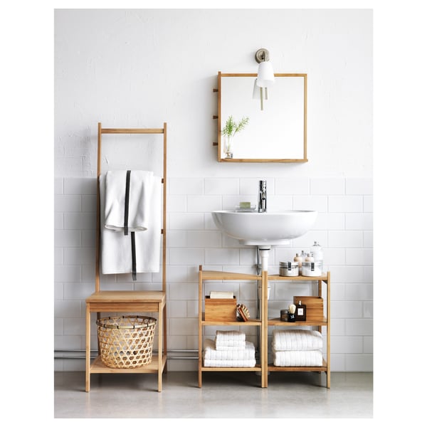 Modern bathroom with white sink, bamboo shelves, ladder towel holder, and mirror.