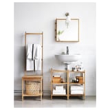 Modern bathroom with white sink, bamboo shelves, ladder towel holder, and mirror.