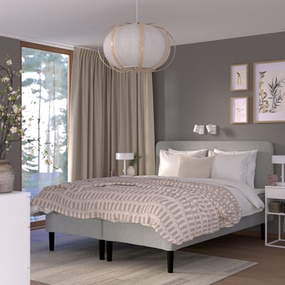 Modern bedroom with grey RÅHOLMAR bed, white pillows, patterned beige comforter, large hanging light, and bedside table.