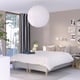 Modern bedroom with king-size white bed, black and white decor, large window, and hanging lamp.