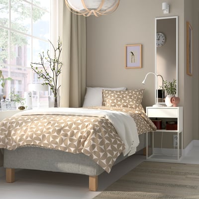 Minimalist bedroom with RÅHOLMAR bed, bedside table, decor, clock, light, bedding, plants.