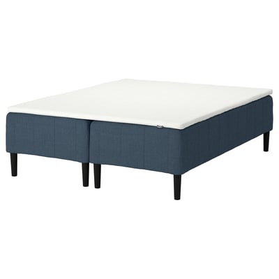 RÅHOLMAR bed base in blue fabric. White mattress, wooden legs, and sleek design.
