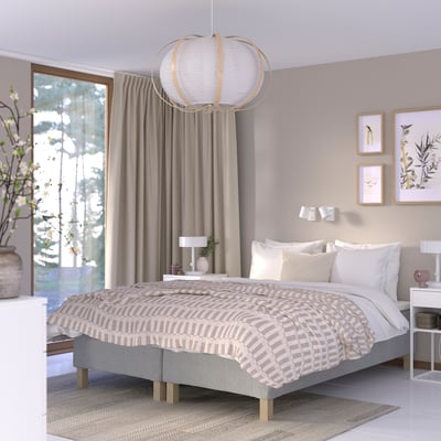 Modern bedroom with RÅHOLMAR bed, neutral tones, pendant light, decorative pillows, and patterned duvet.