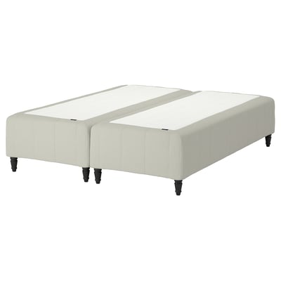 The RÅHOLMAR bed base in white with wooden legs, featuring a modern upholstered design.