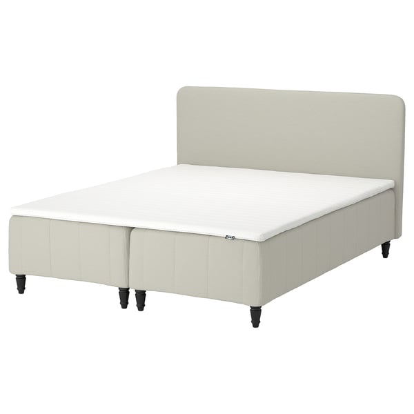 A beige RÅHOLMAR bed with an upholstered headboard and crisp white bedding.