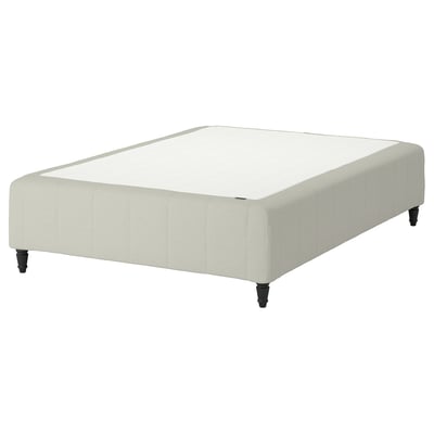The RÅHOLMAR bed base is cream-colored with beige upholstery, featuring four dark wood legs and a tufted design.