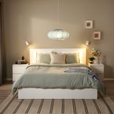 Bedroom with large, round, white REGNSKUR lamp. Modern, minimalist design, spacious, well-lit.